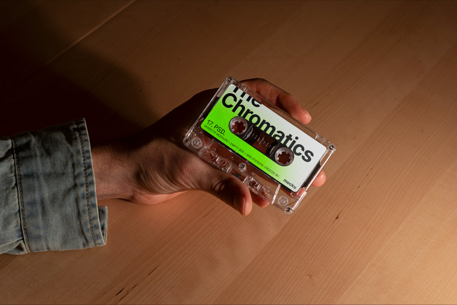 Cassette Mockup Held in Hand Over Wooden Surface